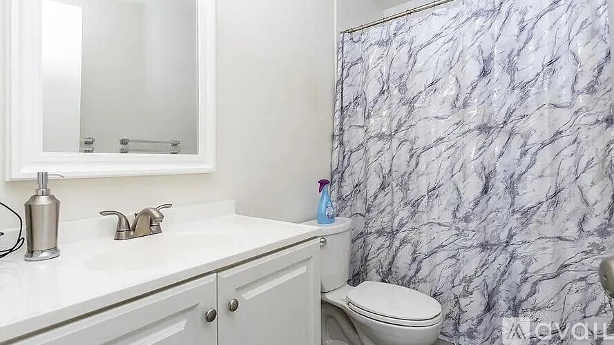 A white bathroom with a marble wallpaper.