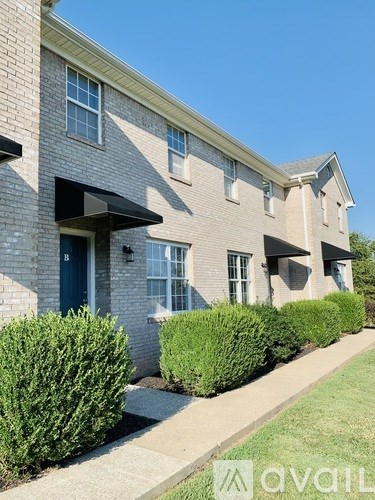 A brick building with a blue door and windows.