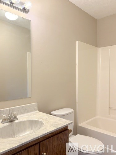 A white sink in a bathroom with a toilet and a bathtub.
