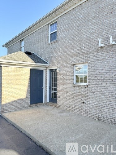 A house with a grey brick exterior and a blue door.