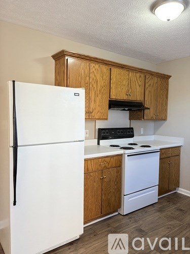 A kitchen with wooden cabinets and a white refrigerator.