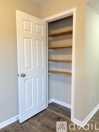 A white door with a shelving unit in the corner of a room.