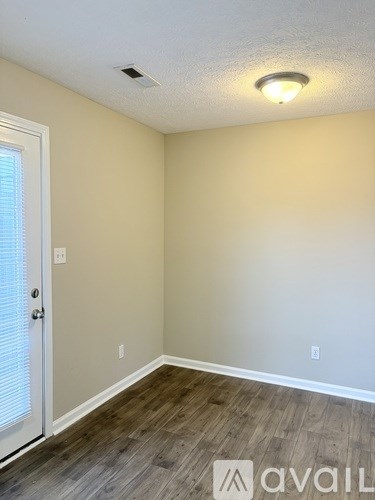 A room with a wooden floor and a white door.