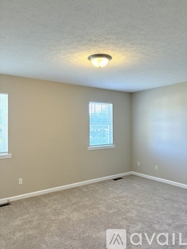 A room with a carpeted floor and a window.