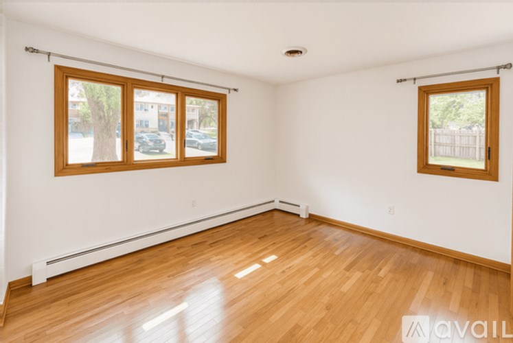 A room with wooden floors and two windows.
