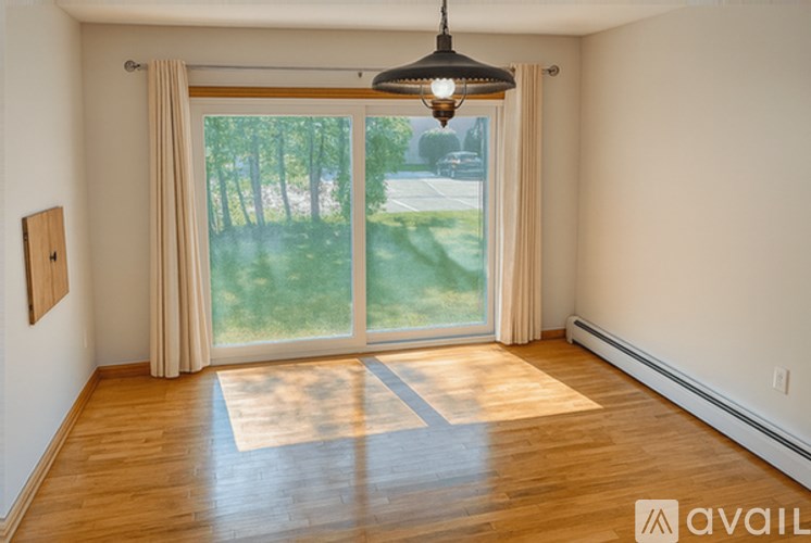 A room with a large window and a wooden floor.