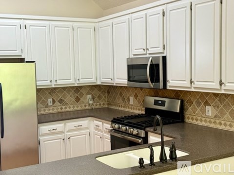 A kitchen with white cabinets and a black stove top oven.