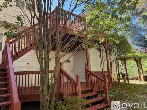 A tree is in front of a white house.