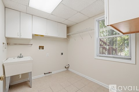 A bathroom with a sink, a window with blinds, and a skylight.