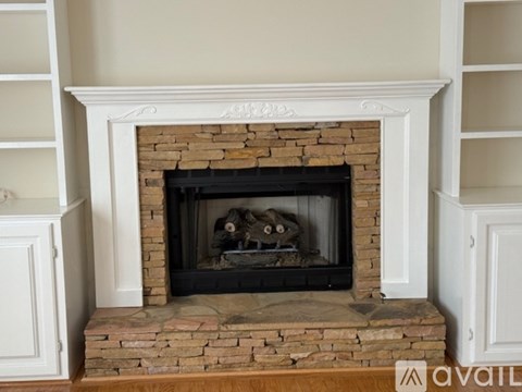 A fireplace with a white mantle and a stone base.