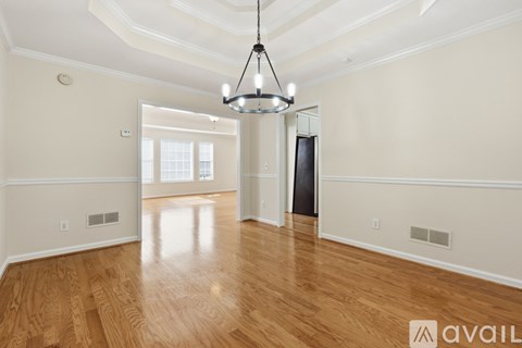 A room with a ceiling fan and a window overlooking a green area.
