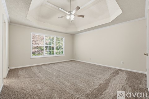 Empty room with a ceiling fan and a window.