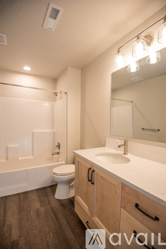 A bathroom with a toilet, sink, and mirror.