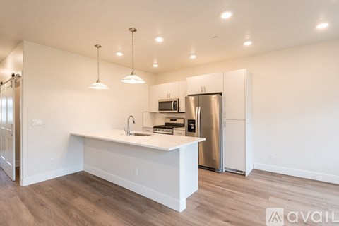 A kitchen with a white counter and stainless steel appliances.