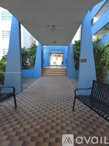 A hallway with blue walls and a checkered floor.