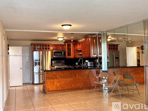A kitchen with a brown counter top and silver appliances.