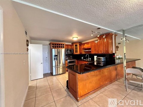 A kitchen with wooden cabinets and a black countertop.