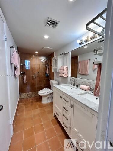 A bathroom with a toilet, sink, and mirror.