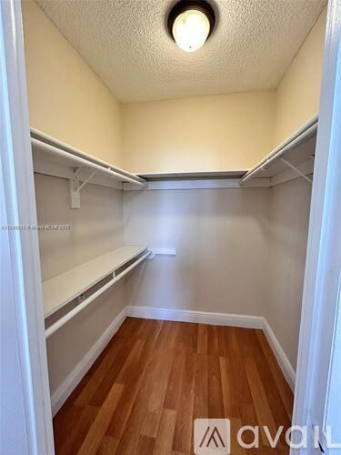A small, empty room with wooden floors and white walls.