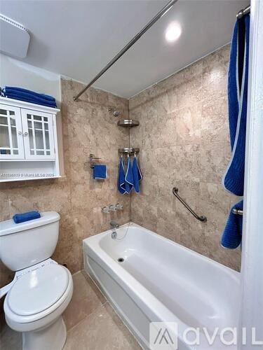 A bathroom with a white toilet and a white bathtub.