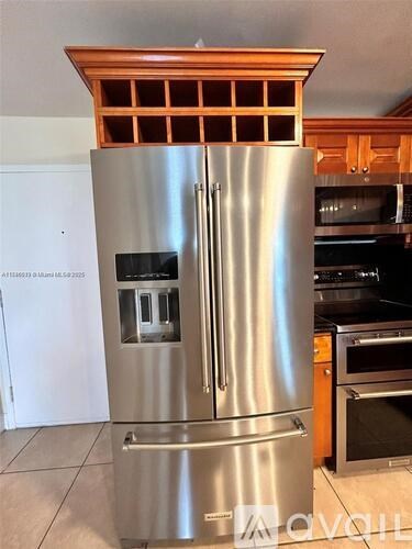 A stainless steel refrigerator with a wooden top and freezer compartment.