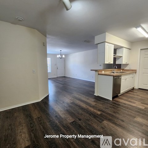 A kitchen with white cabinets and a wooden floor.