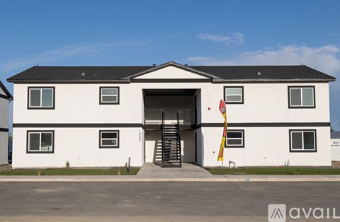 A white building with a black roof and a flag in front.