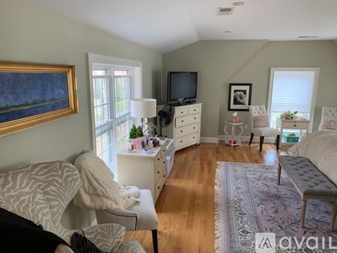A living room with a couch, a television, and a painting on the wall.