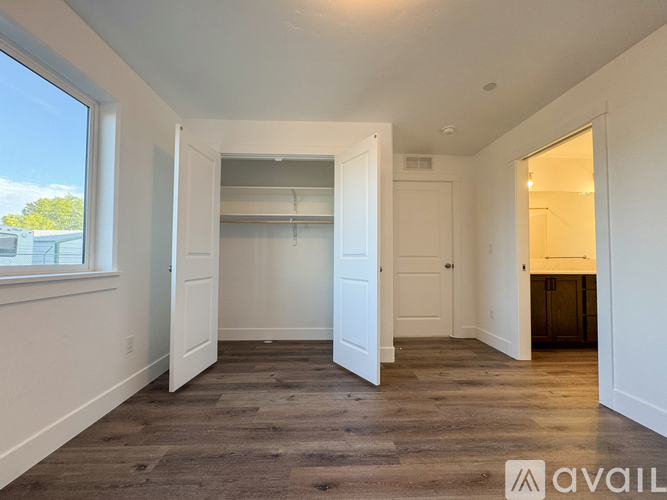 A room with white walls and a wooden floor is available for rent.