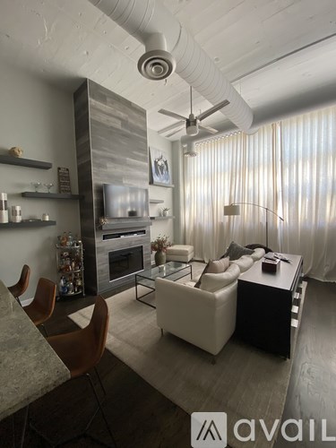 A modern living room with a white ceiling fan and a white couch.