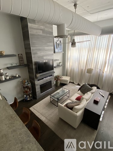 A modern living room with a glass coffee table and a white couch.