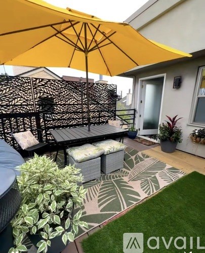 A yellow umbrella is open over a black metal bench.