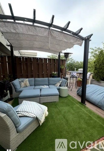 A patio with a white canopy and a grey couch.
