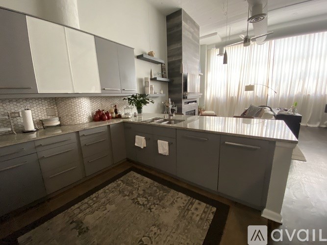 A kitchen with a large island and grey cabinets.