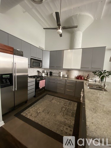 A kitchen with a refrigerator, microwave, and oven.