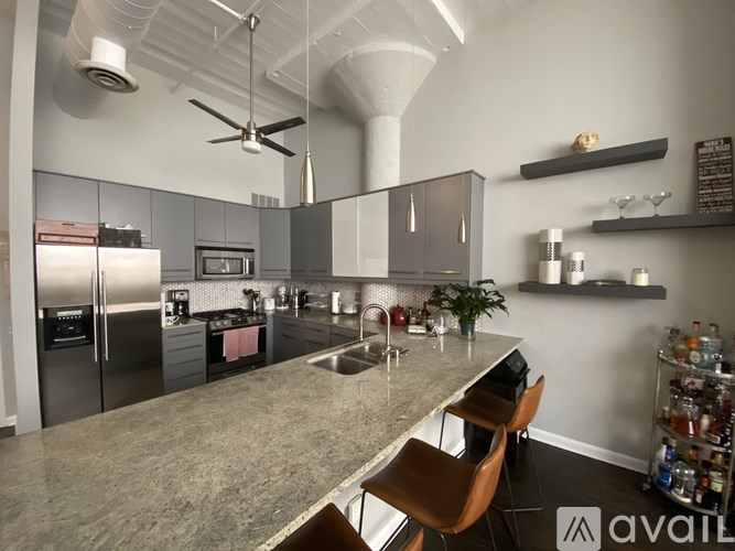 A modern kitchen with a marble countertop and stainless steel appliances.