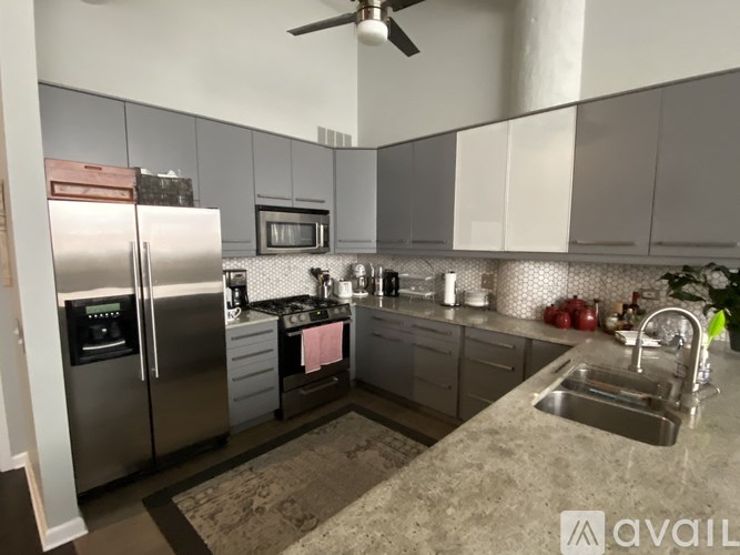 A kitchen with a refrigerator, microwave, and sink.
