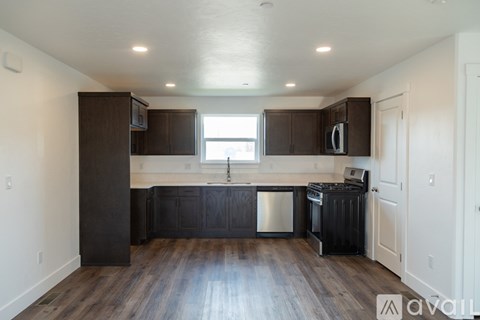 A kitchen with dark wood cabinets and a stainless steel dishwasher.