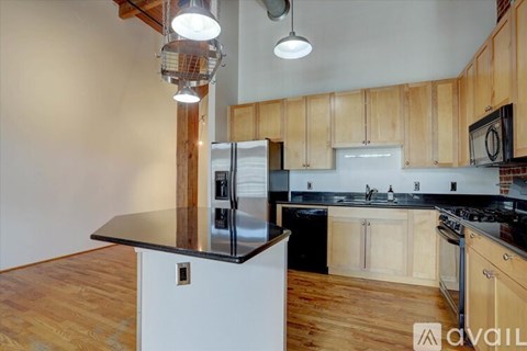 A kitchen with wooden cabinets and a black countertop.