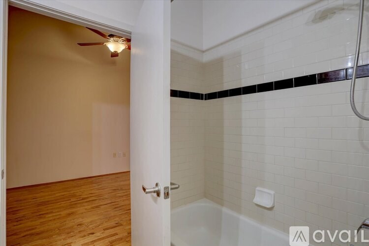 A bathroom with a white tub and a white door.