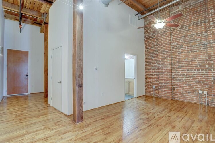 A room with wooden floors and a brick wall.