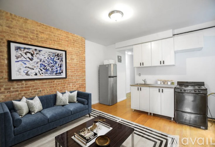 A living room with a blue couch and a brick wall.