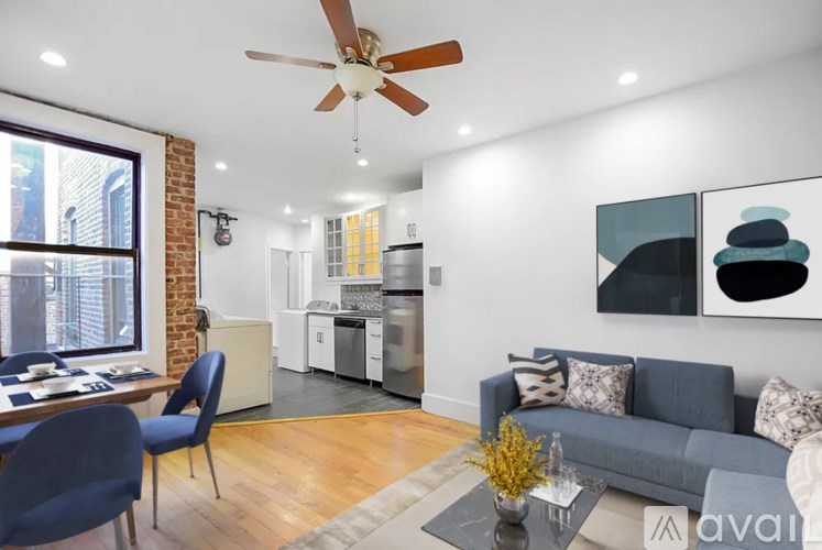 A living room with a grey couch and a ceiling fan.