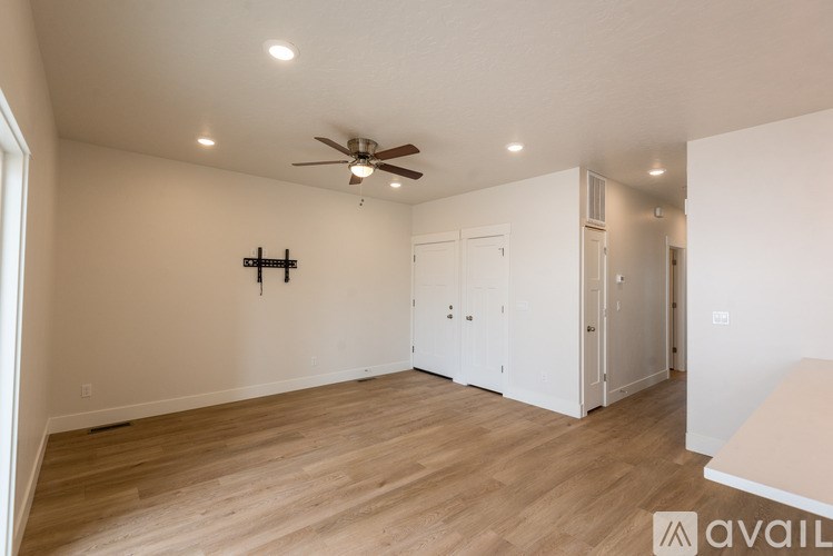 A spacious room with a ceiling fan and lighting fixtures.