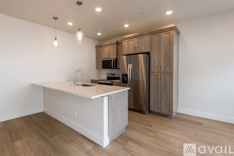 A kitchen with a white countertop and wooden cabinets.
