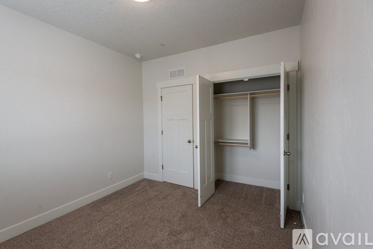 A room with a carpeted floor and a white door.