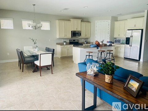A kitchen and living room with a dining table and chairs.