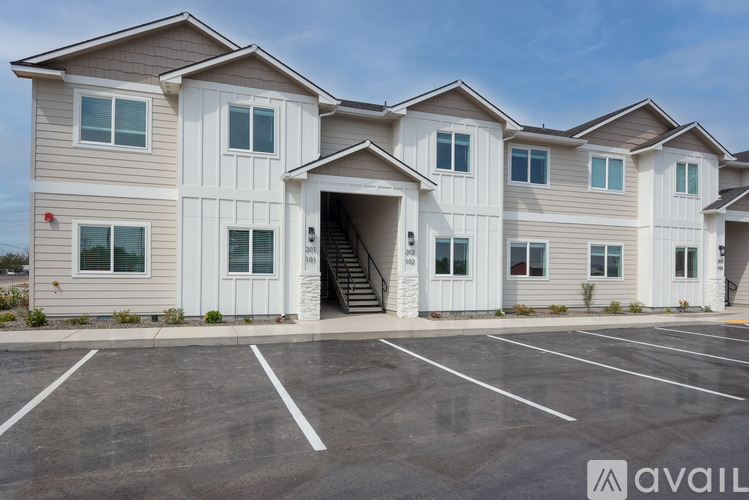 A row of houses with a parking lot in front.