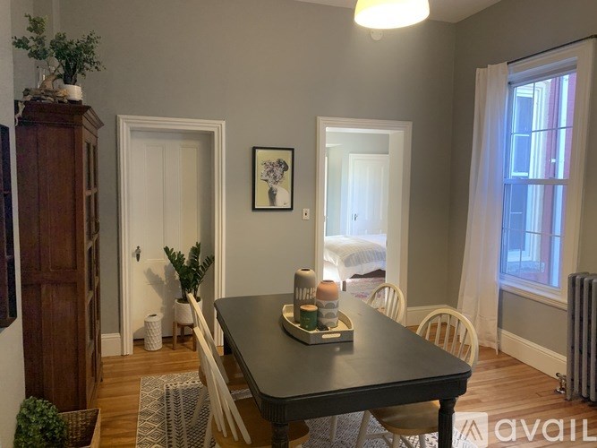 A dining room with a wooden table and chairs.