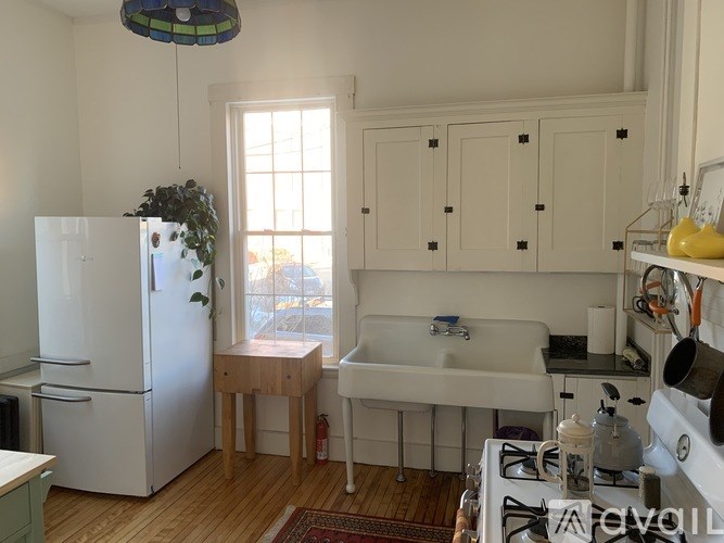 A kitchen with a white fridge and a white sink.